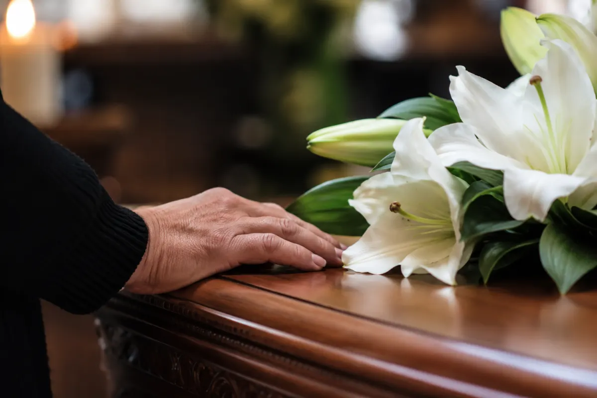 Bouquet de fleurs blanches pos&eacute; sur un cercueil lors d'un hommage fun&egrave;bre